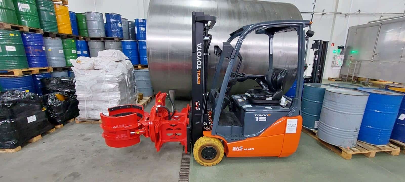 ATIB red forklift clamp mounted on Toyota electric forklift in warehouse with barrels